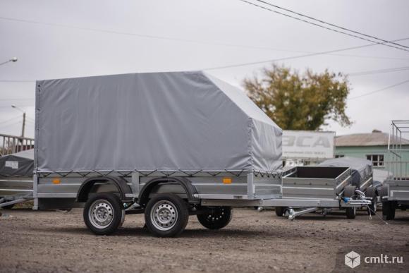 Двухосный прицеп Титан 3015 с колесами и скошенным тентом. Фото 1.