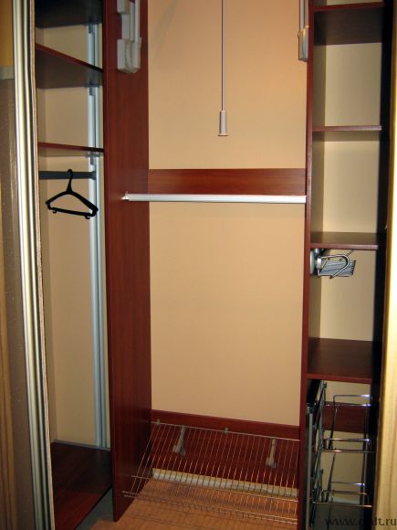 Гардеробная комната оборудована двумя вариантами полок под обувь, галстучницой, вешалами и пантографом.